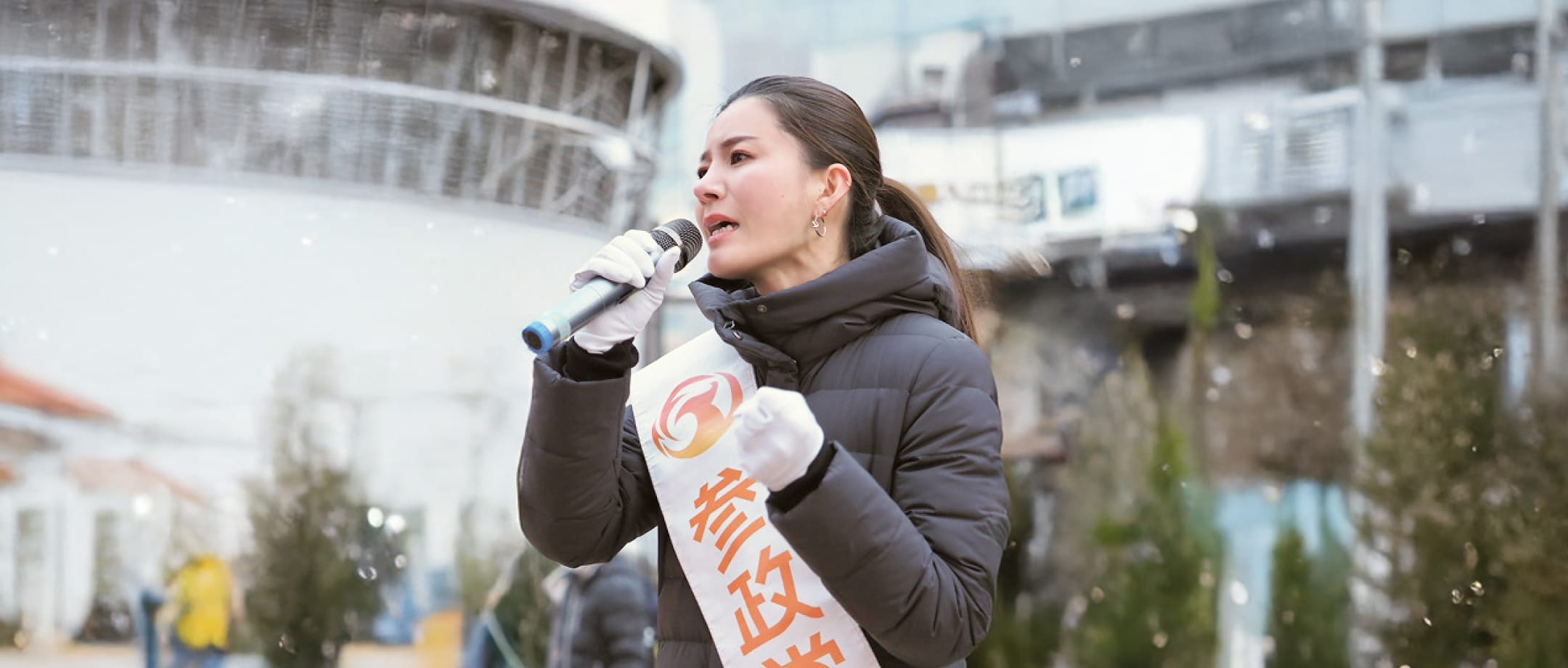 街頭でマイクを使って演説する吉川りな
